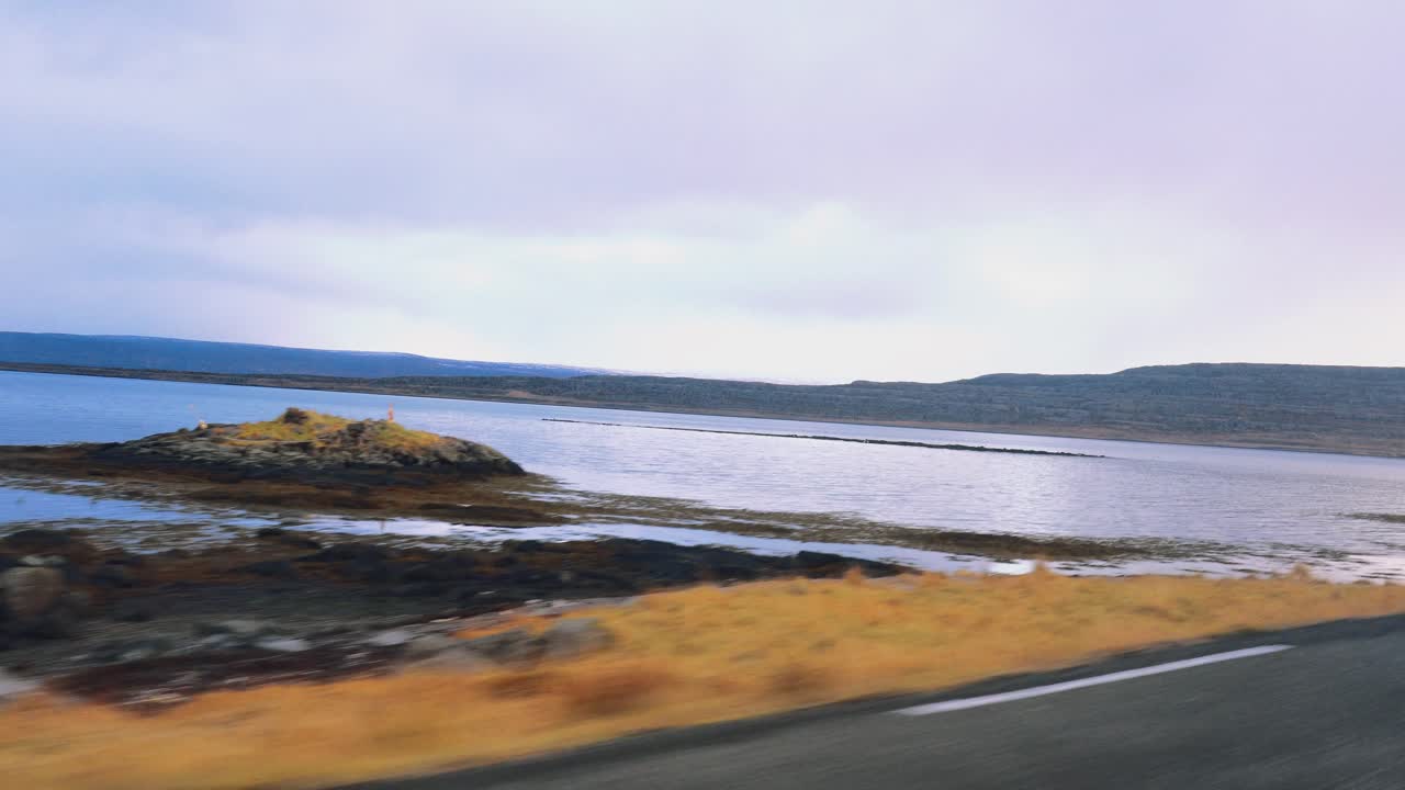 Pov view perspective af iceland road with black sand beach, arctic sea on the left and cloudy sky in autumn