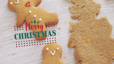 animation of merry christmas text over snowman shape cookies with mold on wooden table