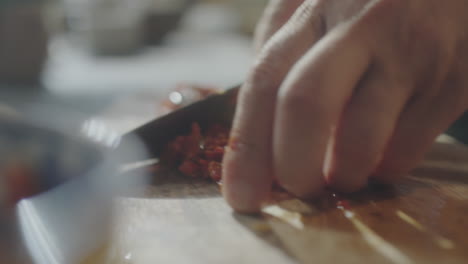 close-up of hands chopping ingredients on a cutting board