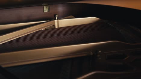 a tight shot of the interior of a grand piano showing the strings