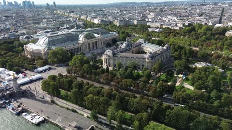 Aerial-drone-view-of-Petit-Palais-and-Grand-Palais-in-Paris-with-financial-district-in-background,-France