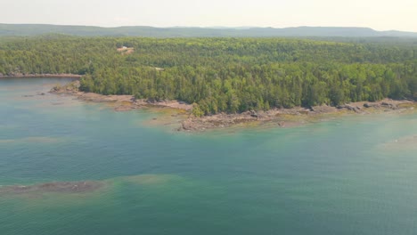 aerial view of a lake with forest and rocky shore