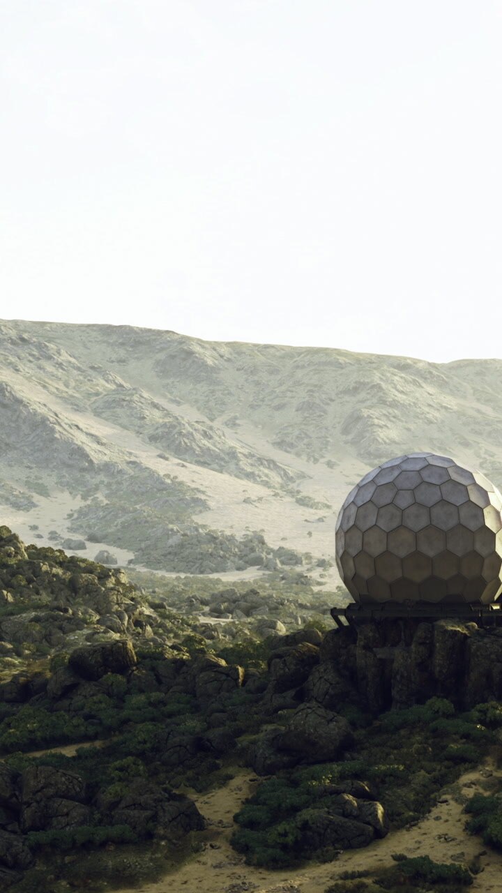 Structure sits on rocky landscape near mountains in bright daylight