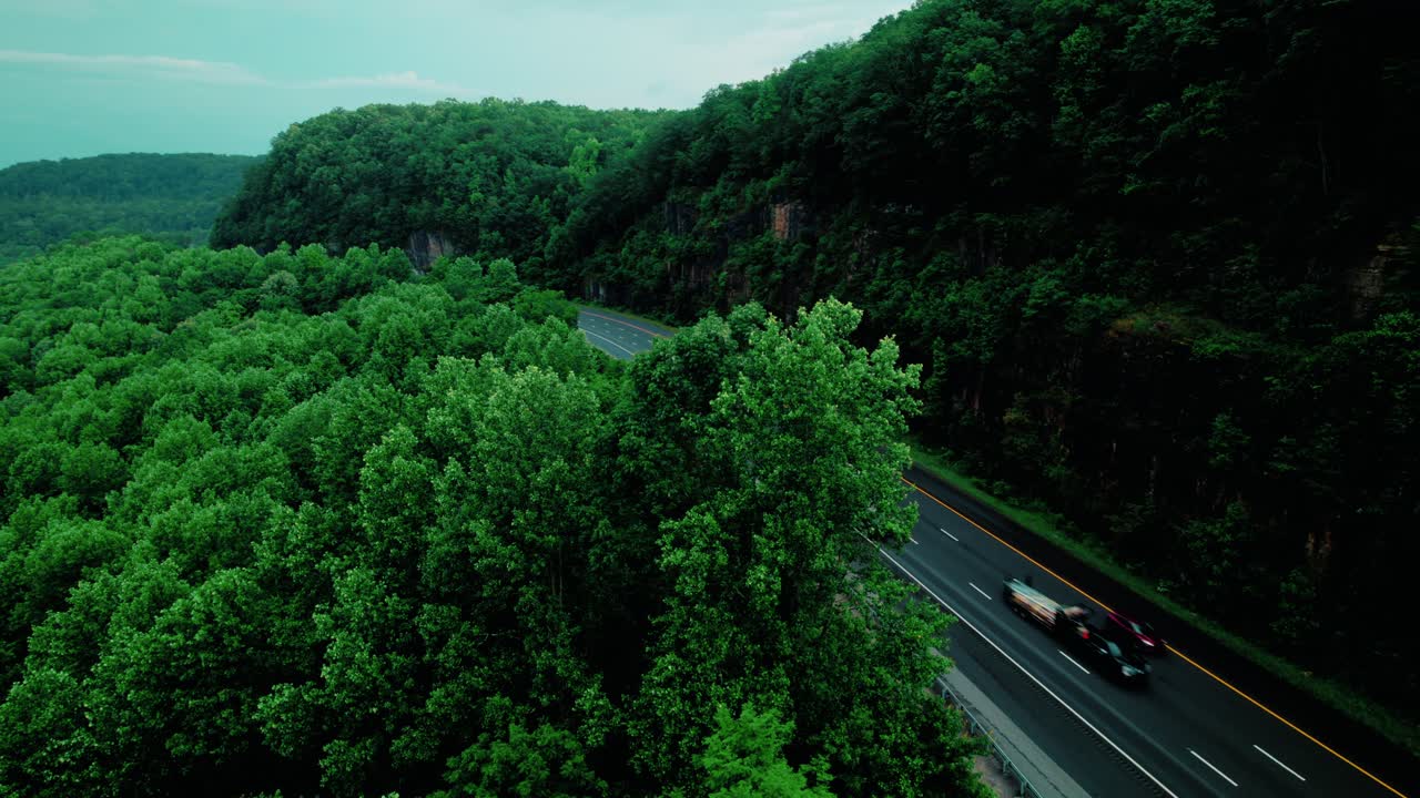 Orbiting aerial of semi truck drivers transporting cargo along I-24 through Monteagle, Tennessee, heavy-duty logistics operations