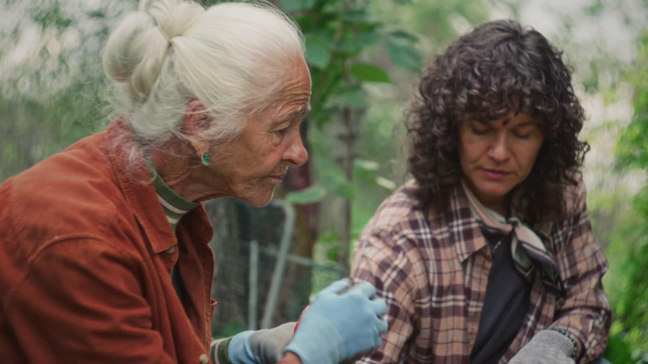 Senior Woman Discussing Autumn Harvest with Granddaughter in Garden