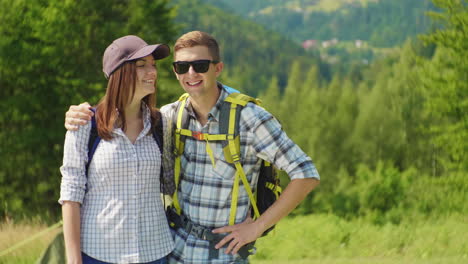 Portrait-Of-A-Couple-Of-Happy-Tourists-With-Backpacks-Smile-Look-At-The-Camera-4K-Video