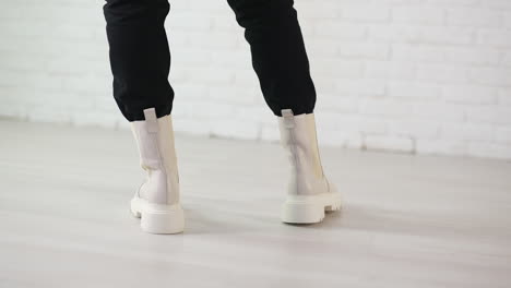 woman wearing cream colored platform ankle boots with black pants
