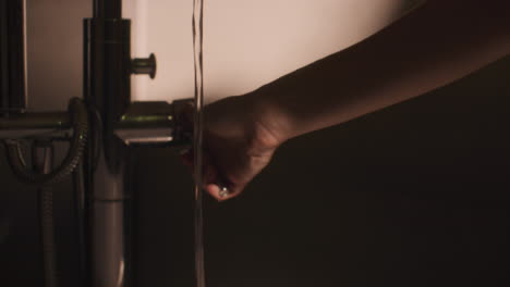 person washing hands at a bathroom sink