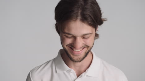 caucasian confident man in front of camera on gray background.