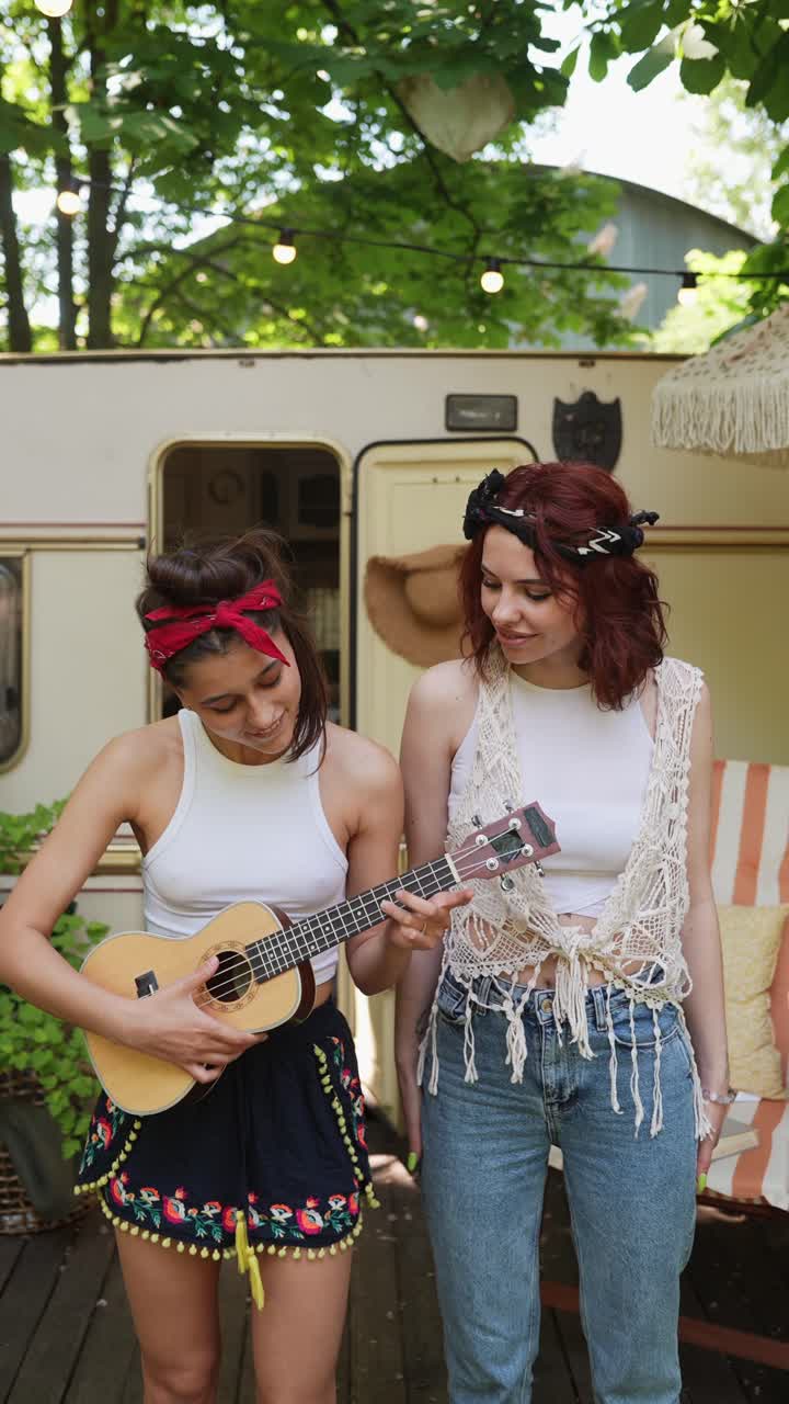 Due donne che suonano l'ukulele all'aperto