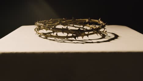 concepto religioso filmado con el primer plano de la corona de espinas en el altar en el charco de luz 2