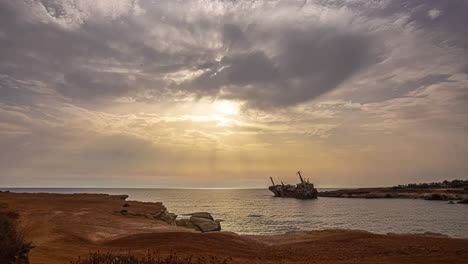 sun bursting over seascape with edro iii shipwreck in cyprus during sunrise