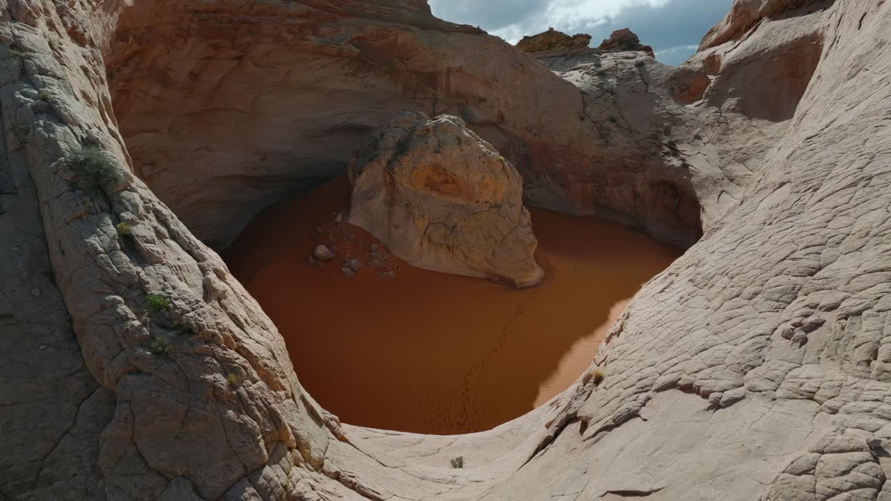 Drone che riprende il bacino di arenaria Cosmic Ashtray con sabbia arancione nel deserto dello Utah