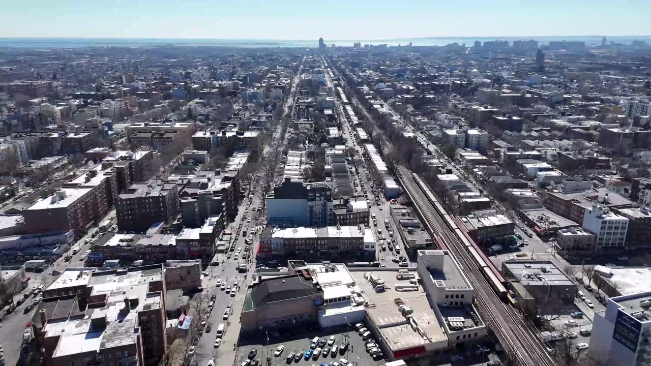 Horizontal drone circular shot over Avenue M in Brooklyn, showcasing the city's vibrant streets, residential buildings, and dynamic urban landscape with smooth aerial rotation.