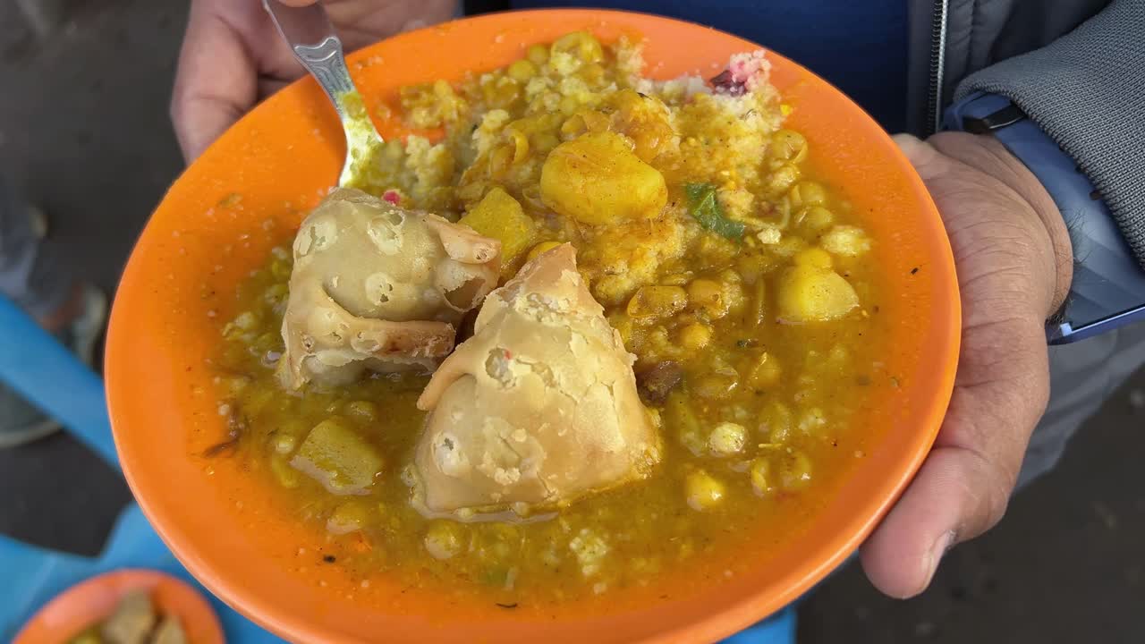 Couple of samosas served with ghugni on plate as breakfast.