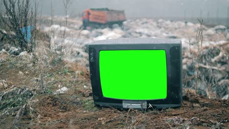 tv with green screen at the landfill site while snowing