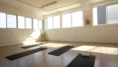 sunlight filling bright yoga studio with mats and blocks ready for class