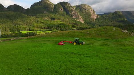 Tractor-Verde-Con-Segadora-Acondicionadora-Cosechando-Campo-Verde,-Producción-De-Ensilaje