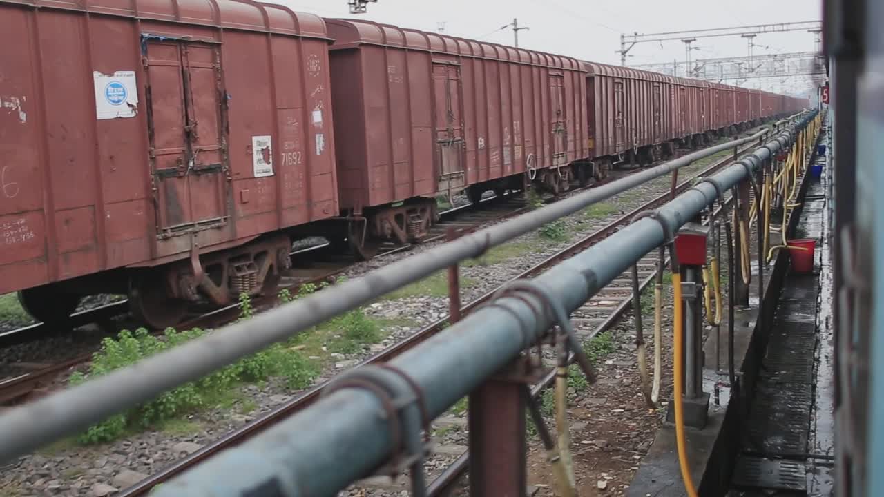 Inquadratura fissa di treni e binari ferroviari che passano in India