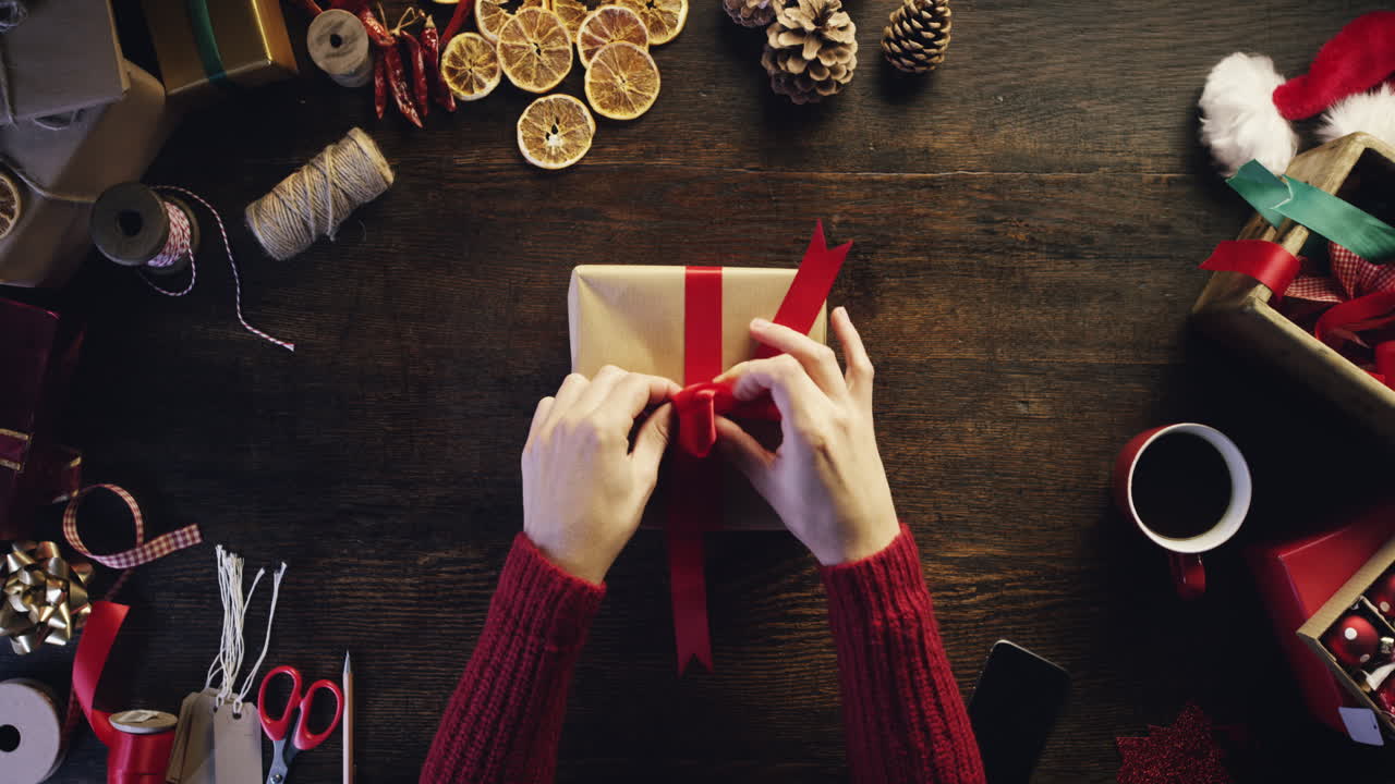 vista superior manos envolviendo regalos de navidad en un escritorio de madera desde arriba - dragón épico rojo