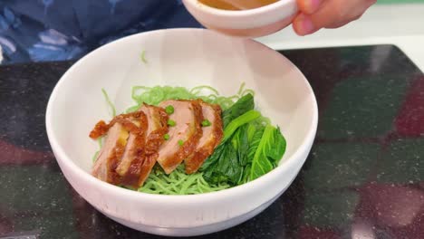 duck noodles with sauce being prepared in bangkok