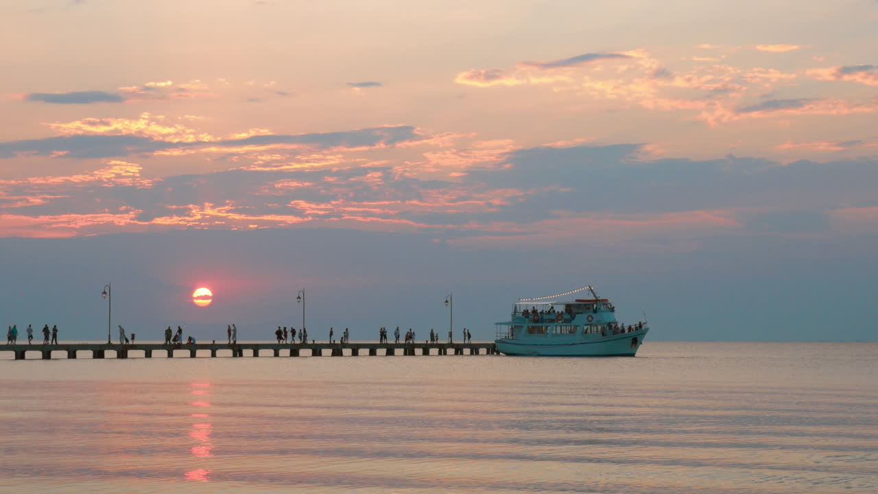 Touristic ship leaving the pier at sunset