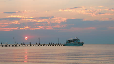 barco turístico que sale del muelle al atardecer