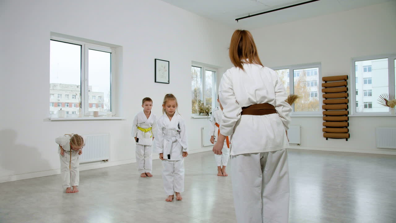 niños en kimono blanco en la clase de artes marciales
