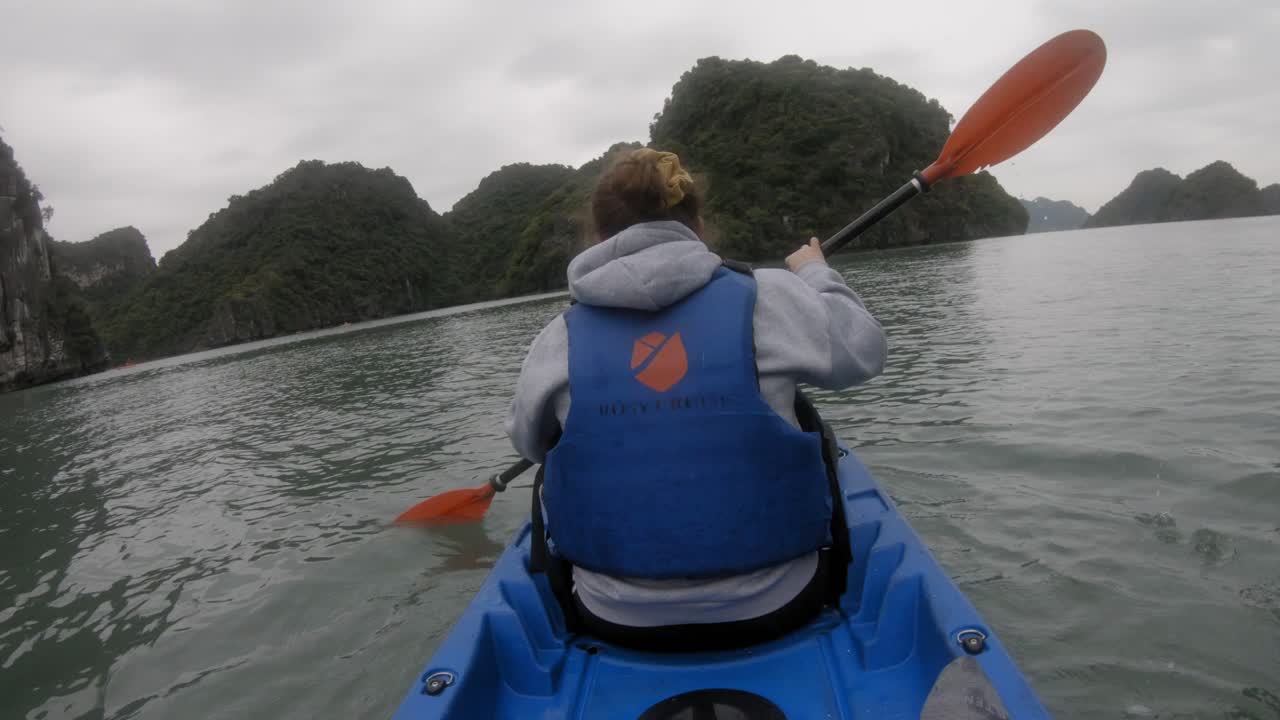 Ripresa in soggettiva di una donna in kayak che pagaia, vista da dietro