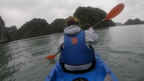 Toma-Pov-De-Una-Mujer-En-Un-Kayak,-Remando-Visto-Desde-Atrás