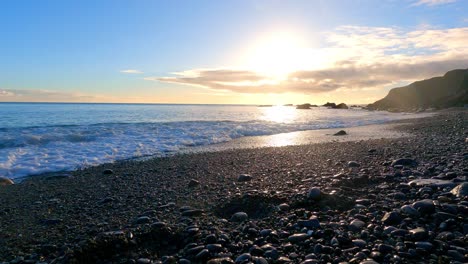 Playa-Idílica-Con-Olas-De-Guijarros-En-La-Hora-Dorada-Y-La-Puesta-De-Sol-En-La-Costa-De-Cobre-De-Waterford,-Irlanda,-Belleza-Natural