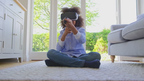 boy sitting on floor in lounge wearing vr headset playing computer game