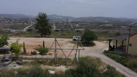 Magen-David,-David-shield-,Israel-Army-infantry-squad-soldiers-on-vehicle-driving-through-green-field-at-training-ground-country-road,-Aerial-Tracking-shot