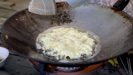 chef pouring omelet in hot pan