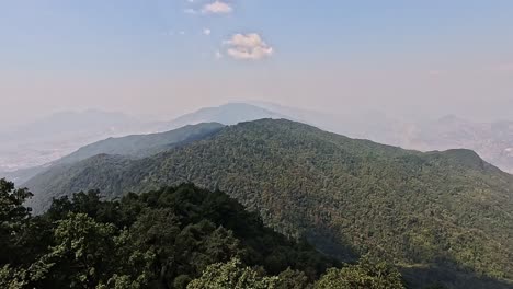 Overlooking-the-forest-and-agricultural-hills-surrounding-Kathmandu,-opening-in-to-the-rural-background