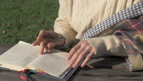 woman writes in diary content in nature outdoors