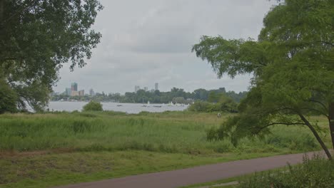 horizonte de rotterdam visto desde kralingse bos en los países bajos con un carril bici en primer plano