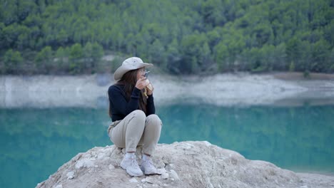 Woman Enjoying a Banana by the Lake