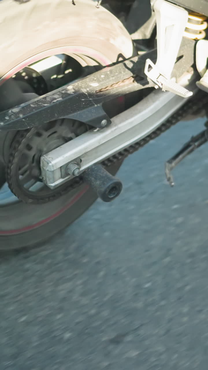 움직이는 전력 자전거를 타는 사람의 클로즈업, 체크 된 셔츠와 스니커를 입고, 자전거의 몸과 바는 부분적으로