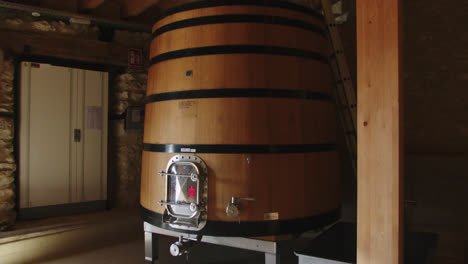 slow motion shot of a large wooden barrel containing wine at temperature in a factory in burgos, spain