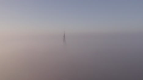 flying towards cornwerd church in friesland with dense fog, aerial