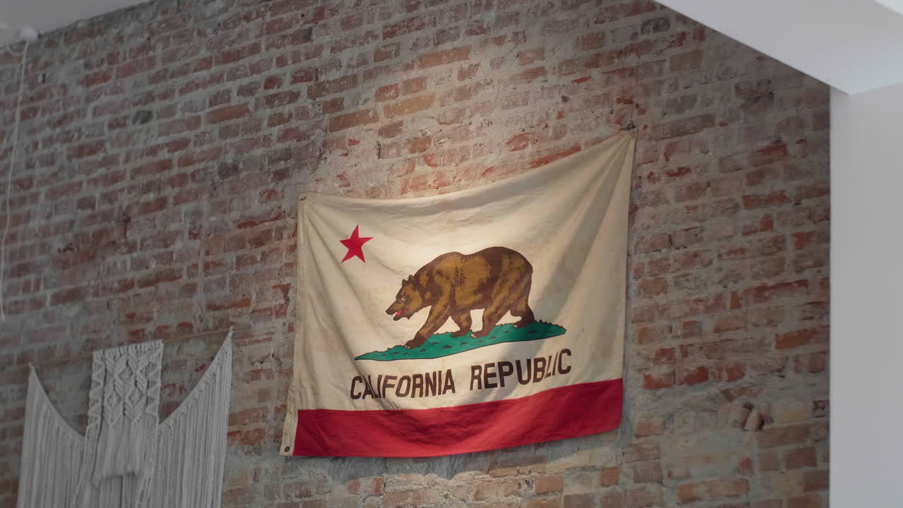 la bandera del estado de california en un telón de fondo de pared de ladrillo rústico