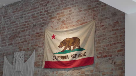 Bandera-Del-Estado-De-California-Sobre-Un-Fondo-De-Pared-De-Ladrillo-Rústico