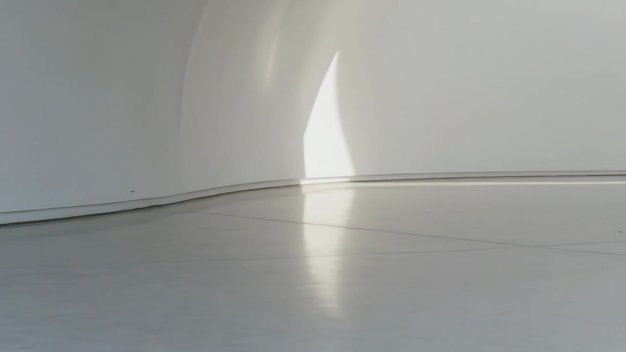 Appare una chiazza di sole a mezzaluna che si restringe, riflettendosi sul pavimento vicino a una parete curva, con la telecamera che si sposta a destra.