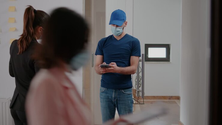 Fattorino con mascherina medica e guanti contro il coronavirus che consegna un pasto da asporto.