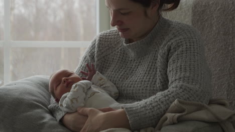 newborn baby sleeping in arms of mother, first home arrival