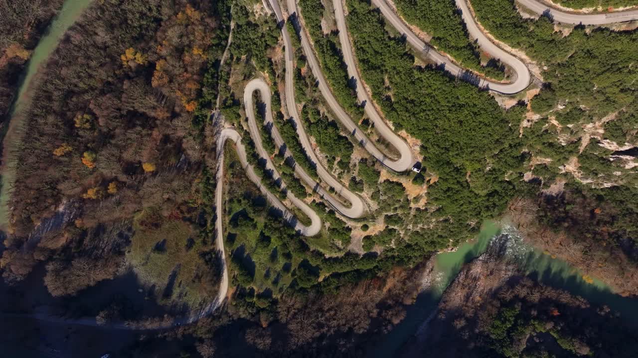 Drone view of cars navigating lush mountain road, Epirus, Greece