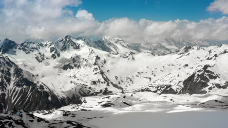 air flight through mountain clouds over beautiful snow-capped peaks of mountains and glaciers.