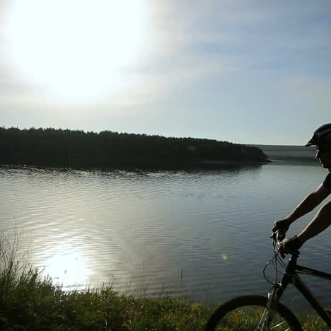 young man with bike at sunset
