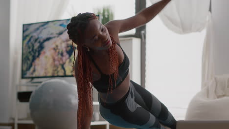 afro american fit woman wearing sportswear doing leg exercises